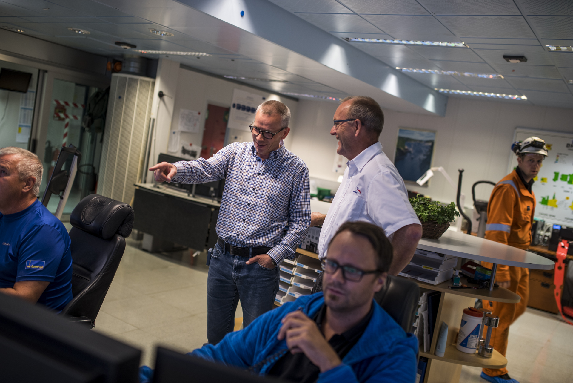 Plattformsjef Øyvind Daae Frøyseth (i midten) forklarer hvordan produksjonen overvåkes og styres fra kontrollrommet.