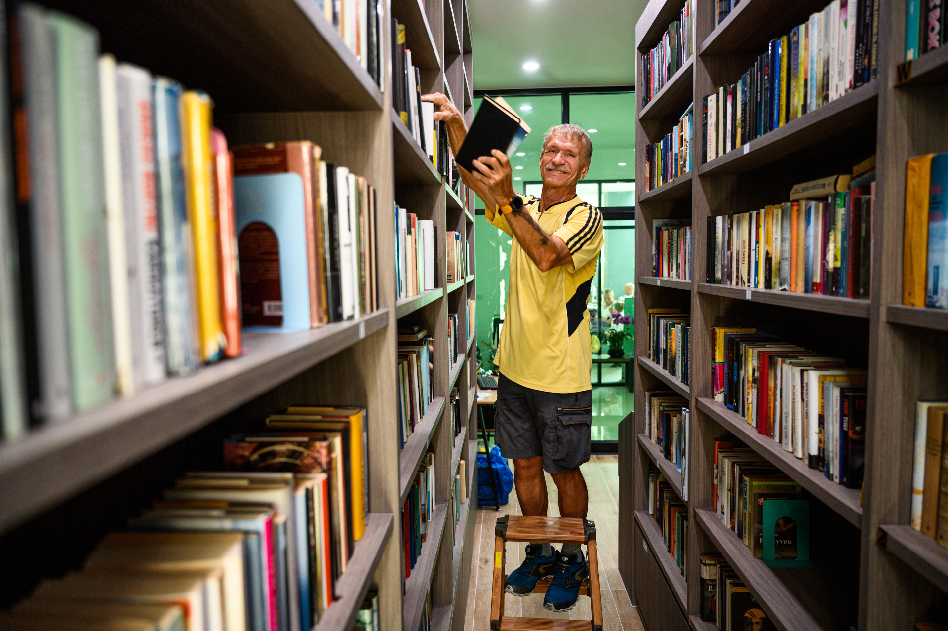 Tromsøværingen Tor Moldenæs hjelper til med å holde det ryddig i sjømannskirkens nye bibliotek.