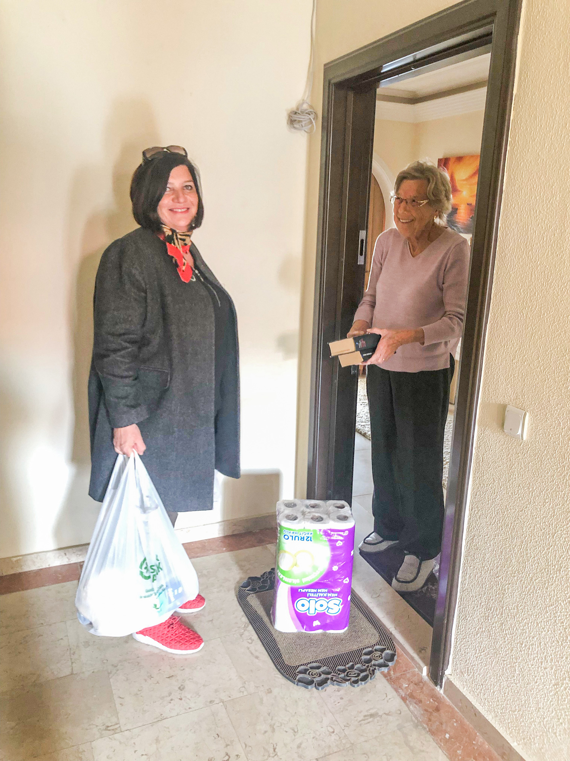 Lisbeth setter pris på varer på døren fra Eva Helland Takvam i Sjømannskirken, og vel så mye den sosiale kontakten vareleveringen medfører.