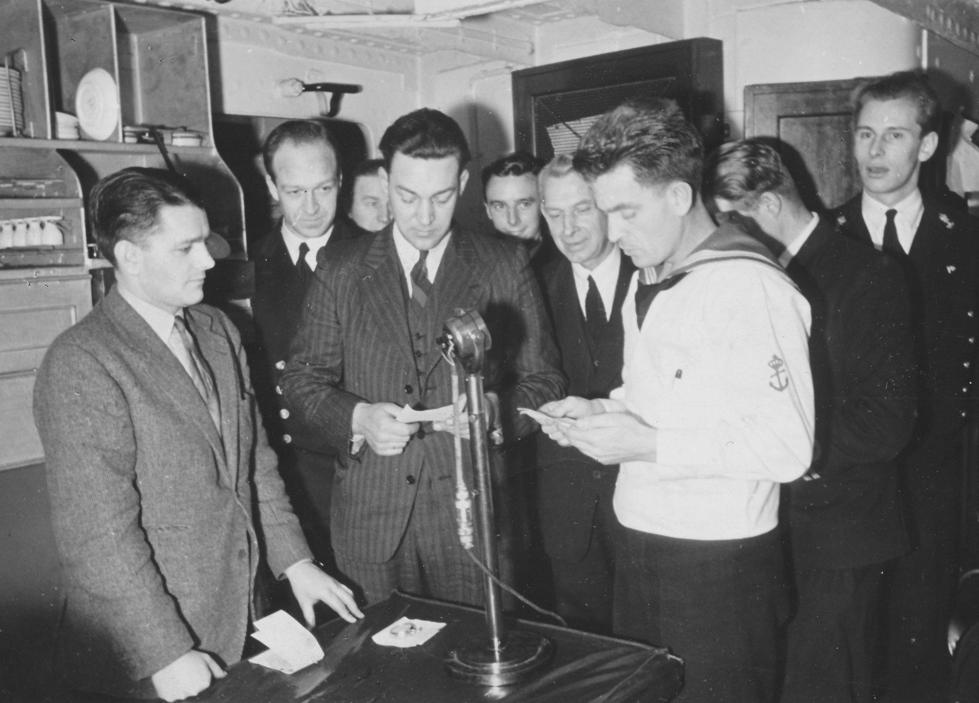 Sjømannskirken i Liverpool ble et trygt holdepunkt i en mørk og turbulent tid. Her er sjømannsprest Alf van der Hagen (i midten) blant sjøfolk på korvetten «Rose», under en radiosending for NRK.
