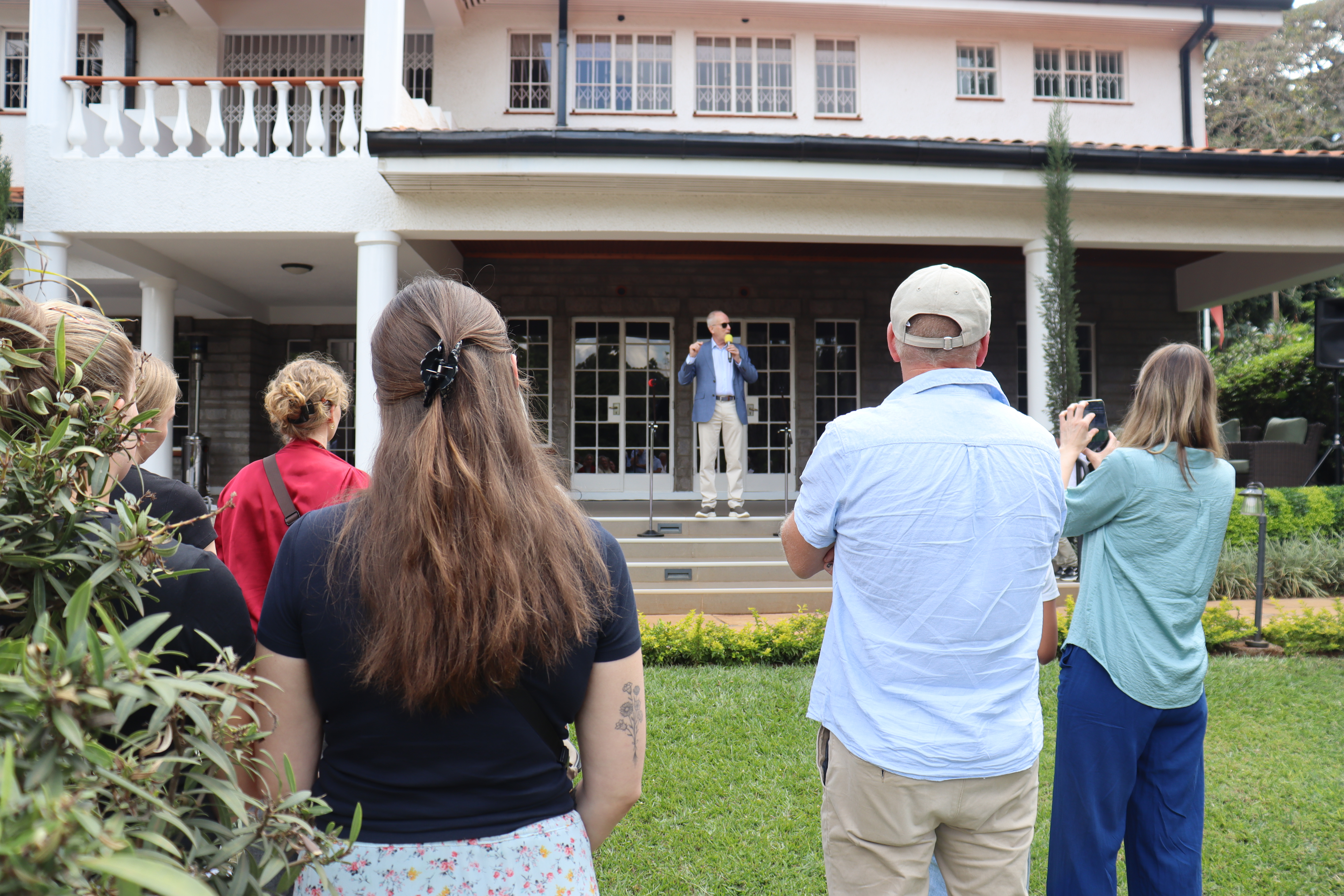 Knut Lyngseth står på trappen utenfor ambassaden og snakker foran nordmennene som har møtt opp.