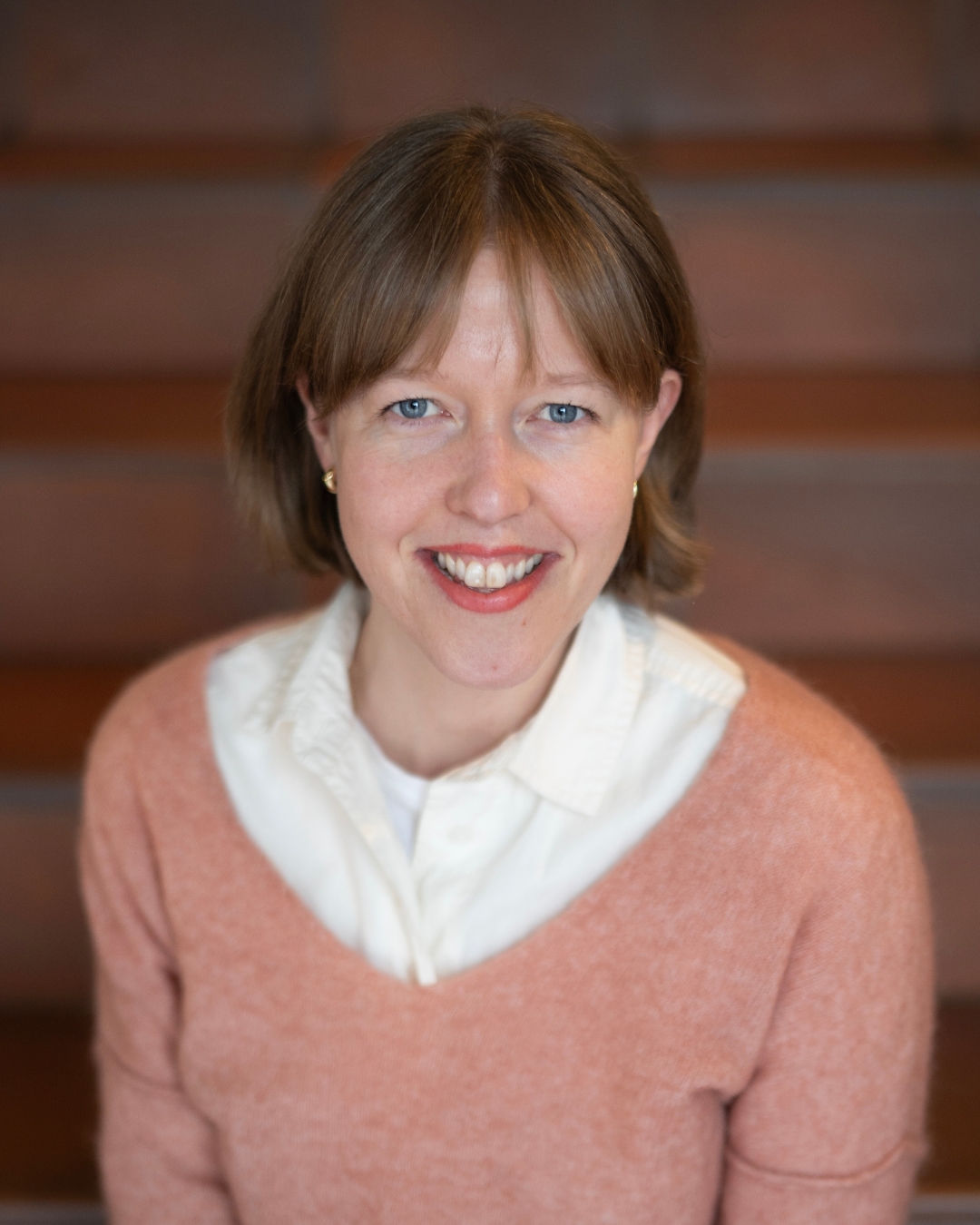 Birgitte Breistein har brunt hår, pannelugg og blå øyne. Hun smiler mot kamera.