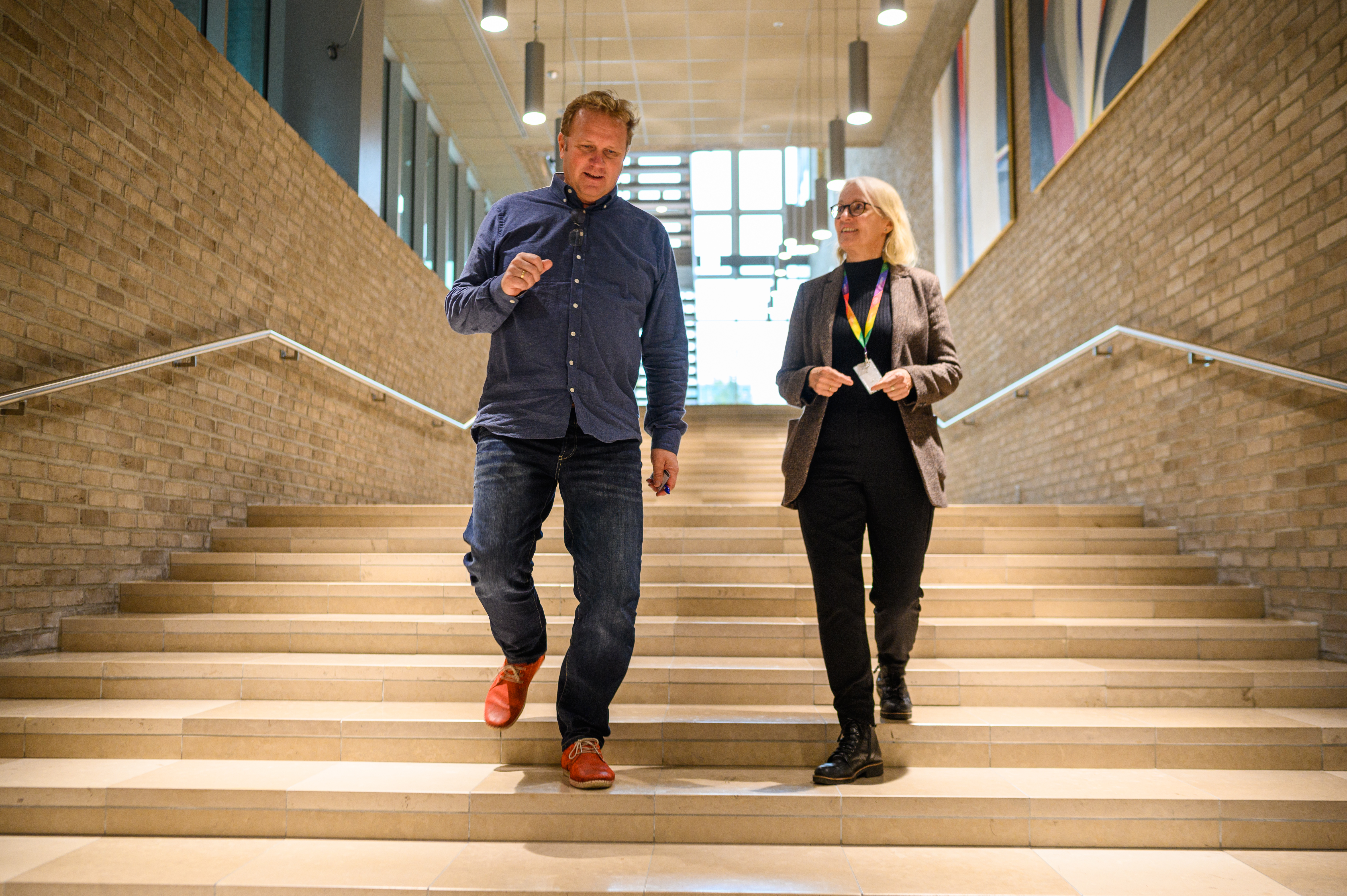 Kursleder Jan Stellef Rønningen og HMS-ansvarlig i DNB, Unni Høiby, i samtale mens gruppene øver med sine veiledere.